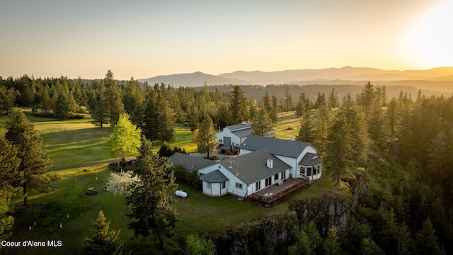 view from above of property featuring a mountainous background and a heavily wooded area
