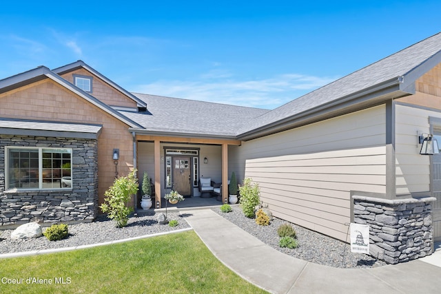 view of front of property featuring stone siding and a shingled roof