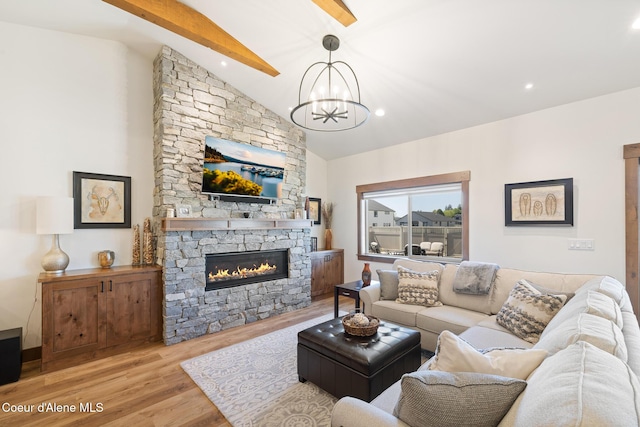 living room featuring wood finished floors, a chandelier, and a fireplace