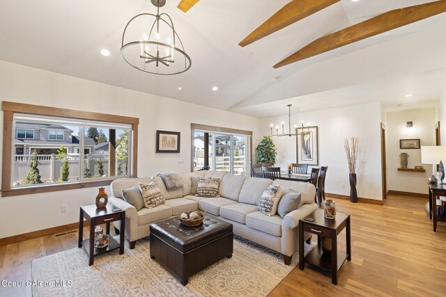 living area featuring a chandelier, plenty of natural light, recessed lighting, and baseboards