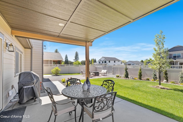 view of patio featuring grilling area, outdoor dining space, and a residential view