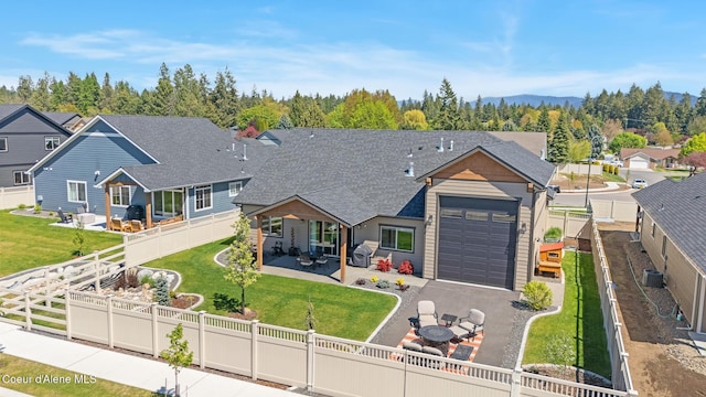 view of front of property with an attached garage, driveway, roof with shingles, a patio area, and cooling unit