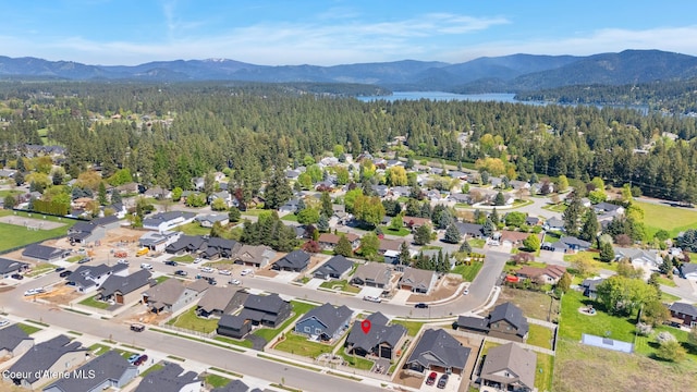 aerial view of residential area featuring a heavily wooded area and a water and mountain view