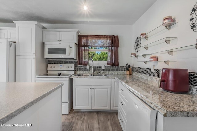 9727 W E St, Worley, ID 83876 - kitchen with white appliances, white cabinets, tasteful backsplash, light countertops, and light wood-style floors