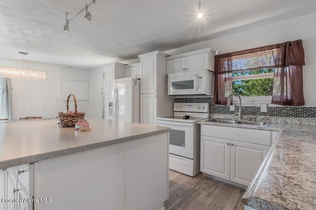9727 W E St, Worley, ID 83876 - kitchen featuring white appliances, light countertops, white cabinets, backsplash, and light wood-style flooring