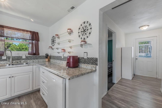 9727 W E St, Worley, ID 83876 - kitchen featuring white dishwasher, healthy amount of natural light, light wood-type flooring, and white cabinetry