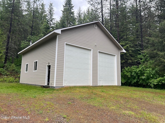 detached garage featuring a forest view