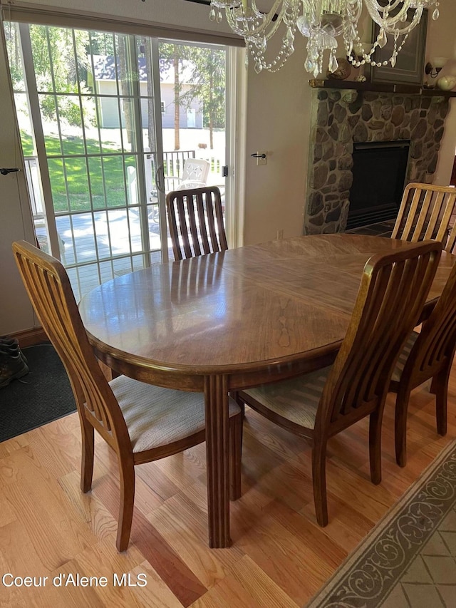 dining area featuring a fireplace, a chandelier, and plenty of natural light
