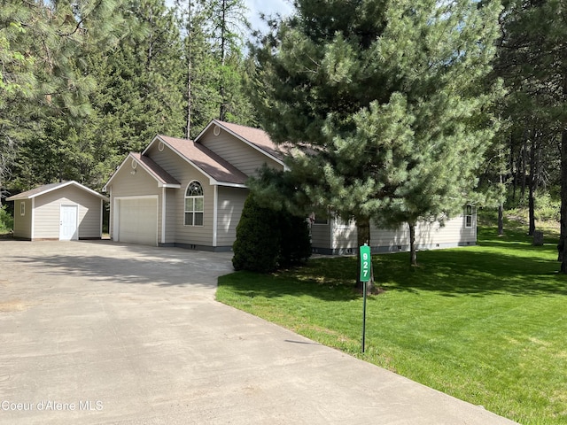 ranch-style house with a shed, an outdoor structure, an attached garage, concrete driveway, and a front yard