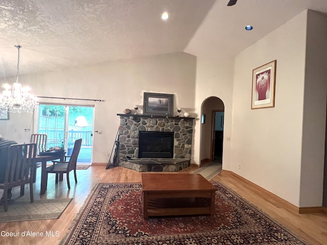 927 Bear Claw Rd, Clark Fork, ID 83811 - living room with wood finished floors, lofted ceiling, arched walkways, a chandelier, and baseboards