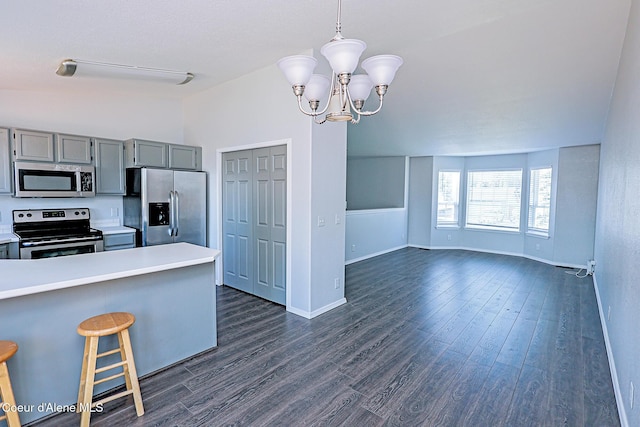 8102 W Arizona St, Rathdrum, ID 83858 - kitchen with stainless steel appliances, gray cabinets, light countertops, dark wood finished floors, and a kitchen bar