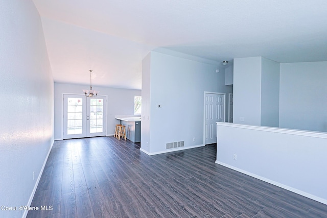 8102 W Arizona St, Rathdrum, ID 83858 - unfurnished living room with dark wood finished floors, a chandelier, and french doors