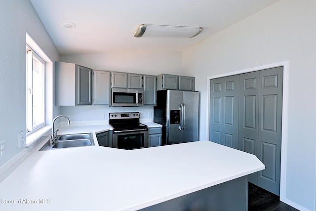 8102 W Arizona St, Rathdrum, ID 83858 - kitchen with appliances with stainless steel finishes, vaulted ceiling, gray cabinets, a peninsula, and light countertops
