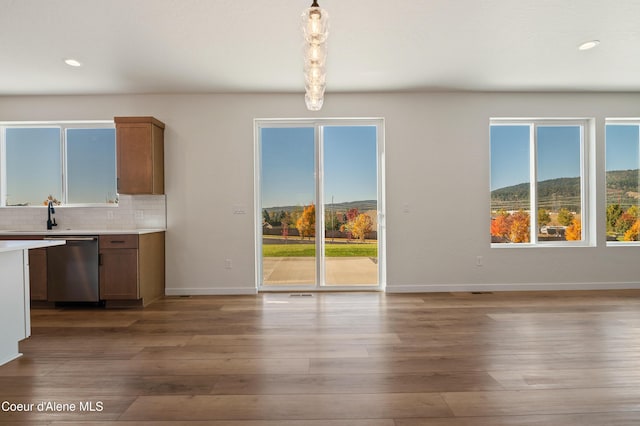 6760 Portrush Dr, Rathdrum, ID 83858 - unfurnished dining area featuring wood finished floors, baseboards, a sink, and recessed lighting