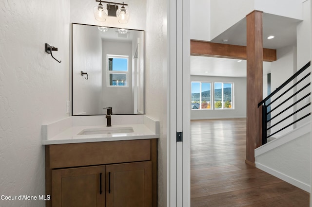 6760 Portrush Dr, Rathdrum, ID 83858 - bathroom featuring vanity, baseboards, a healthy amount of sunlight, and wood finished floors