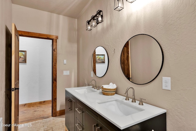 full bathroom featuring a sink, double vanity, and baseboards