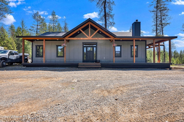 view of front of house with a chimney and covered porch