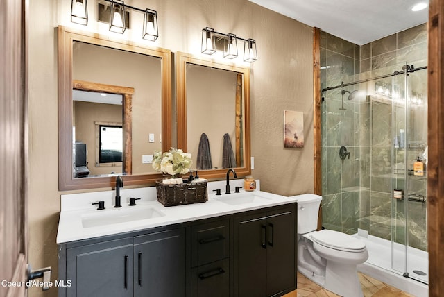 bathroom with double vanity, toilet, a stall shower, and a sink