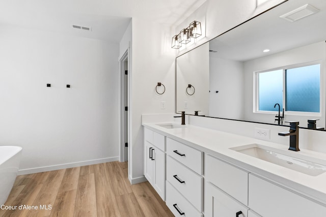 6631 Portrush Dr, Rathdrum, ID 83858 - full bath with a freestanding tub, visible vents, a sink, and wood finished floors