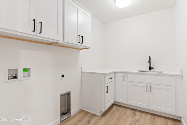 6631 Portrush Dr, Rathdrum, ID 83858 - washroom featuring a sink, cabinet space, light wood-style flooring, electric dryer hookup, and washer hookup