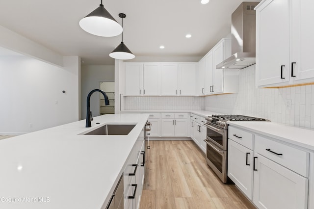 6631 Portrush Dr, Rathdrum, ID 83858 - kitchen with light wood-style flooring, a sink, wall chimney exhaust hood, double oven range, and decorative backsplash
