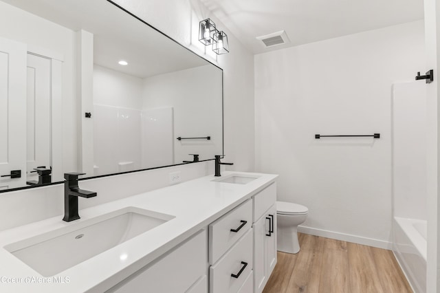 6631 Portrush Dr, Rathdrum, ID 83858 - bathroom featuring toilet, visible vents, a sink, and wood finished floors