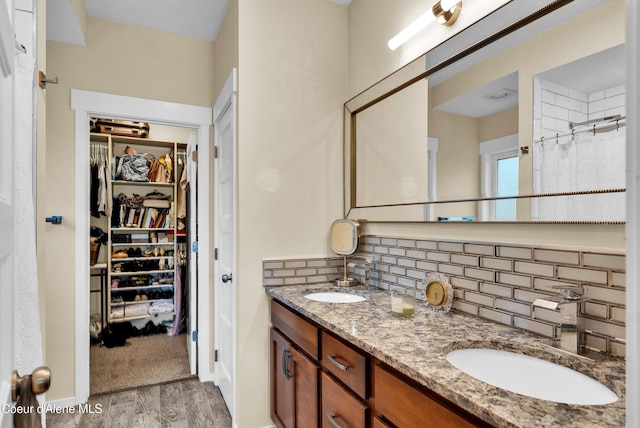 1315 N 10th St, Coeur Dalene, ID 83814 - full bathroom with wood finished floors, decorative backsplash, a spacious closet, double vanity, and a shower with curtain
