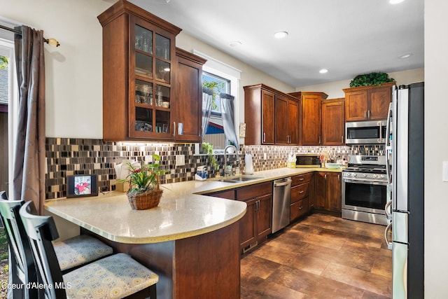 1315 N 10th St, Coeur Dalene, ID 83814 - kitchen featuring stainless steel appliances, a sink, a peninsula, backsplash, and glass insert cabinets