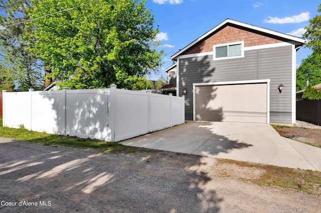 1315 N 10th St, Coeur Dalene, ID 83814 - view of property exterior with concrete driveway, fence, and a garage