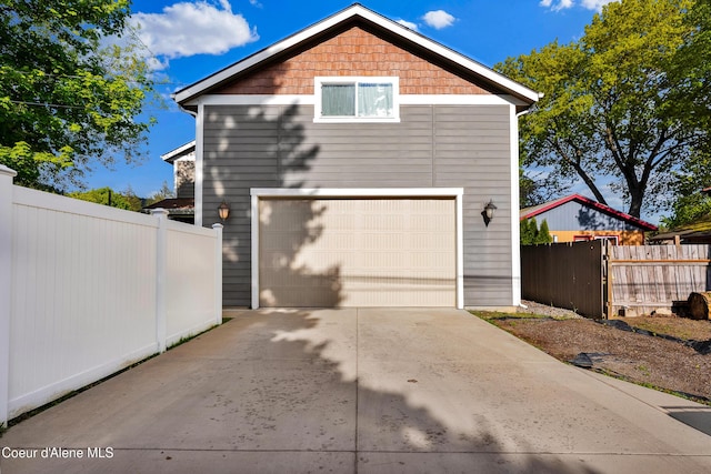 1315 N 10th St, Coeur Dalene, ID 83814 - view of side of home featuring concrete driveway, fence, and a garage