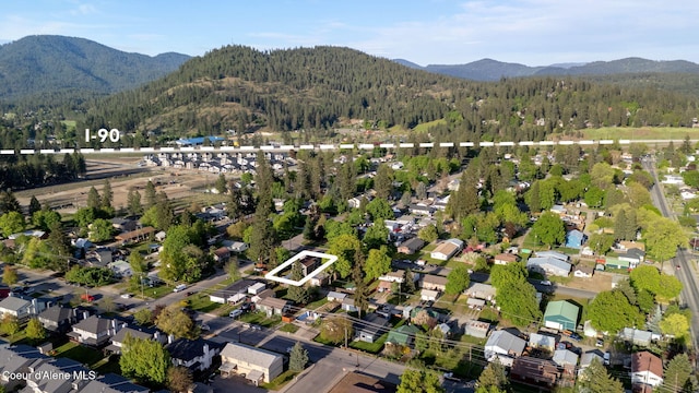1315 N 10th St, Coeur Dalene, ID 83814 - aerial overview of property's location with property boundaries highlighted, a heavily wooded area, a mountain backdrop, and nearby suburban area