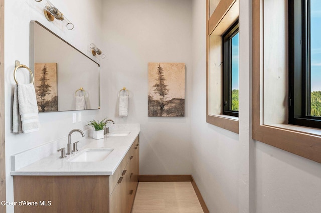 bathroom featuring baseboards, a wealth of natural light, and a sink