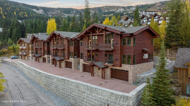exterior space with stone siding, a mountain view, and a balcony