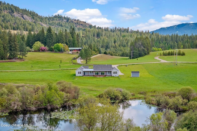 view from above of property with a forest and a water and mountain view