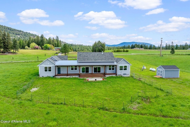 view of front of property featuring an outbuilding, a storage unit, a rural view, metal roof, and a mountain view