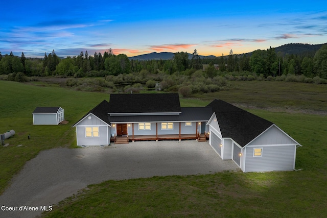view of front of house with gravel driveway, a front yard, an outbuilding, board and batten siding, and a garage