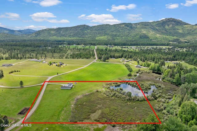 view of property location featuring property parcel outlined, a heavily wooded area, and a water and mountain view
