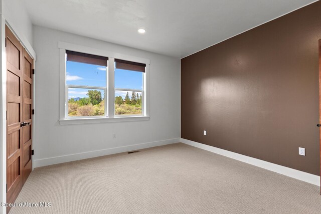 empty room with light carpet, baseboards, and recessed lighting