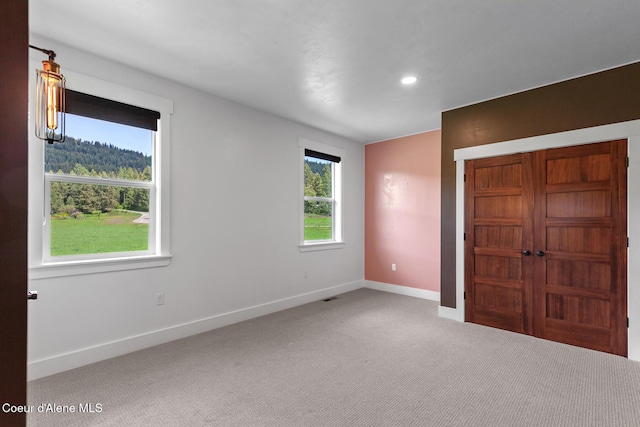 unfurnished bedroom featuring carpet, baseboards, and recessed lighting