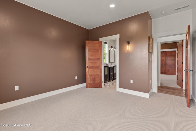 unfurnished bedroom featuring carpet flooring, baseboards, recessed lighting, and connected bathroom