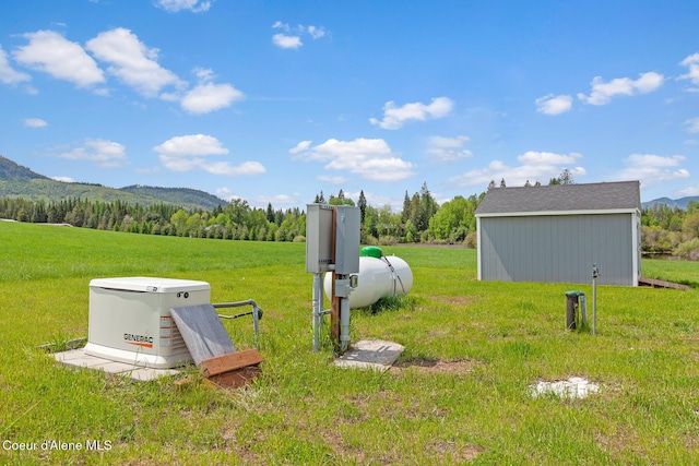 view of grassy yard with a mountain view and an outdoor structure