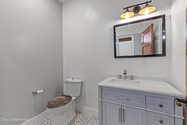 half bath with baseboards, toilet, and vanity