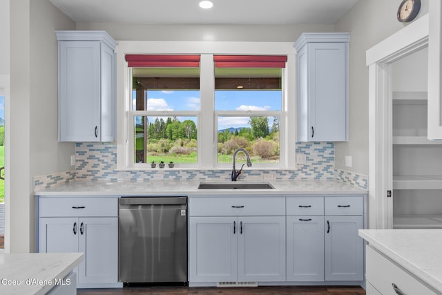 kitchen with dishwasher, a sink, light countertops, tasteful backsplash, and recessed lighting