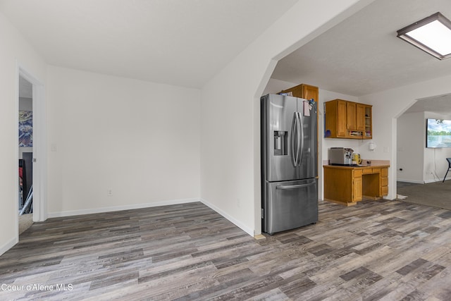 1729 N 9th St, Coeur Dalene, ID 83814 - kitchen featuring stainless steel fridge with ice dispenser, arched walkways, wood finished floors, brown cabinets, and baseboards