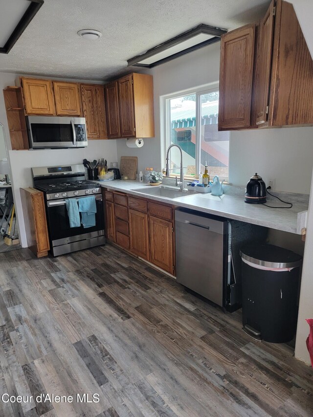 1729 N 9th St, Coeur Dalene, ID 83814 - kitchen with stainless steel appliances, dark wood finished floors, light countertops, a textured ceiling, and brown cabinetry