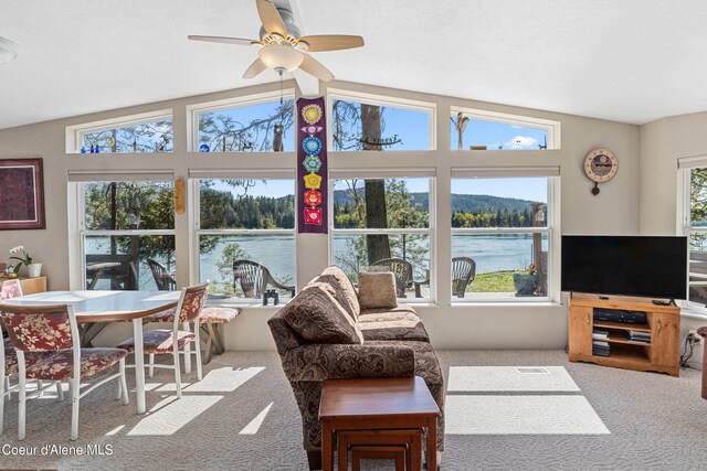 carpeted living area featuring lofted ceiling and a ceiling fan