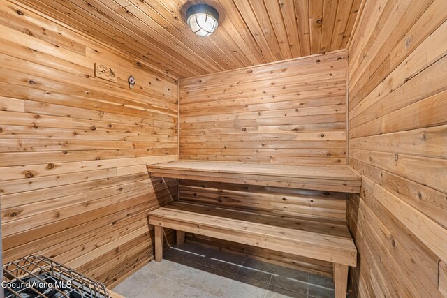 sauna / steam room featuring wooden walls, wood ceiling, and tile patterned floors