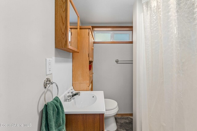 full bathroom featuring toilet, vanity, baseboards, and curtained shower