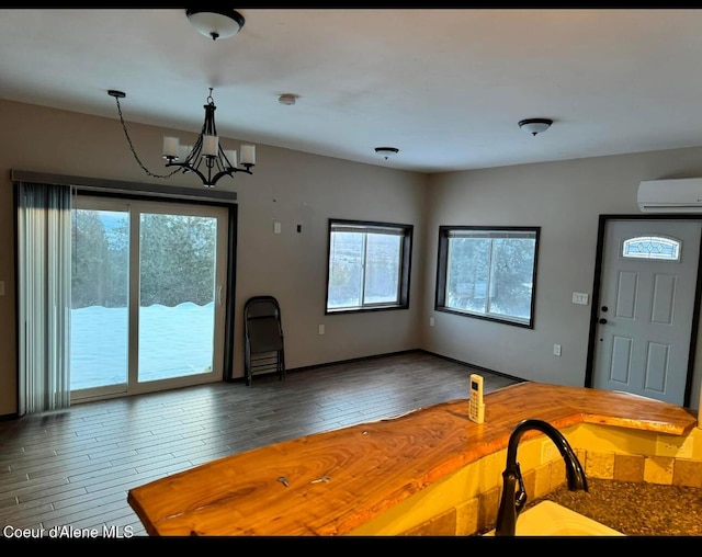 10320 N Payment Peak Rd, Hauser, ID 83854 - unfurnished dining area featuring an AC wall unit, a chandelier, and hardwood / wood-style flooring