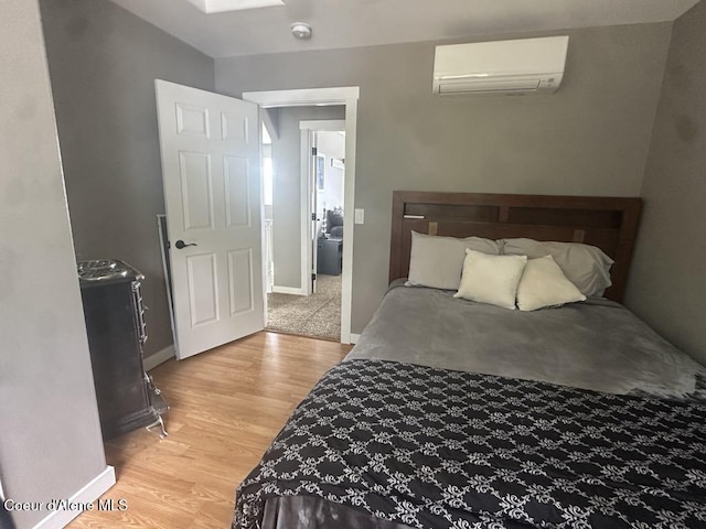 10320 N Payment Peak Rd, Hauser, ID 83854 - bedroom with a wall mounted air conditioner, light wood-type flooring, baseboards, and a skylight